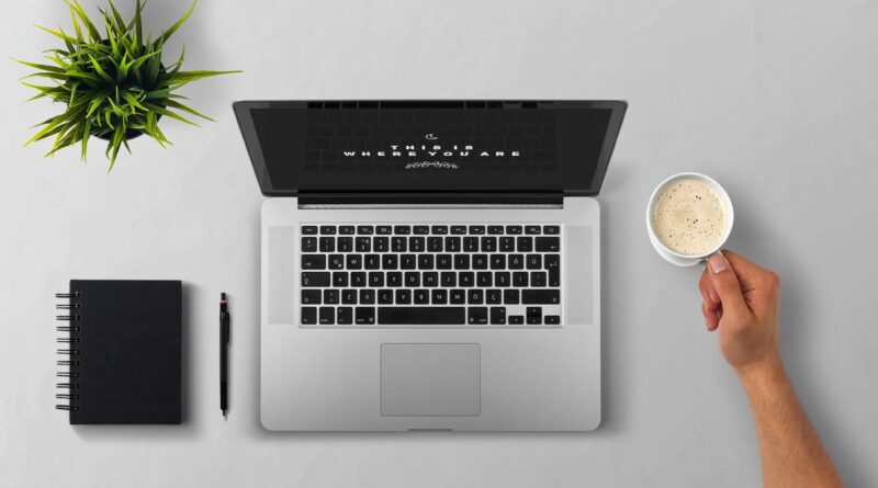 handwriting notes next to laptop on desk